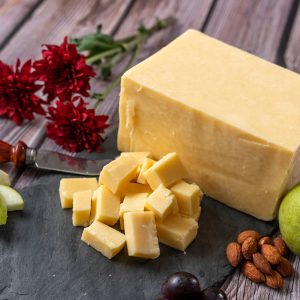 Redmond Cheddar platter with almonds, fruit, and decorative flowers; a sharp and complex cheddar from 5 Spoke Creamery